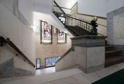 a marble staircase with stained glass windows