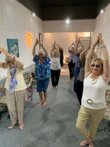a group of older ladies do stretch exercises